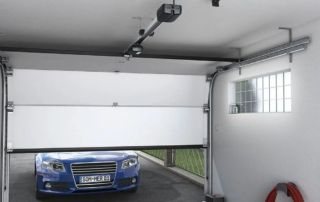 A blue car parked outside a half-open garage door, showcasing a repair service in Appleton.| Bestland Garage Door Service – Green Bay Garage Door Repair