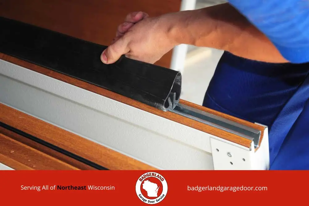 Technician installing weather seal on insulated garage door panel in Northeast Wisconsin by Bestland Garage Door.
