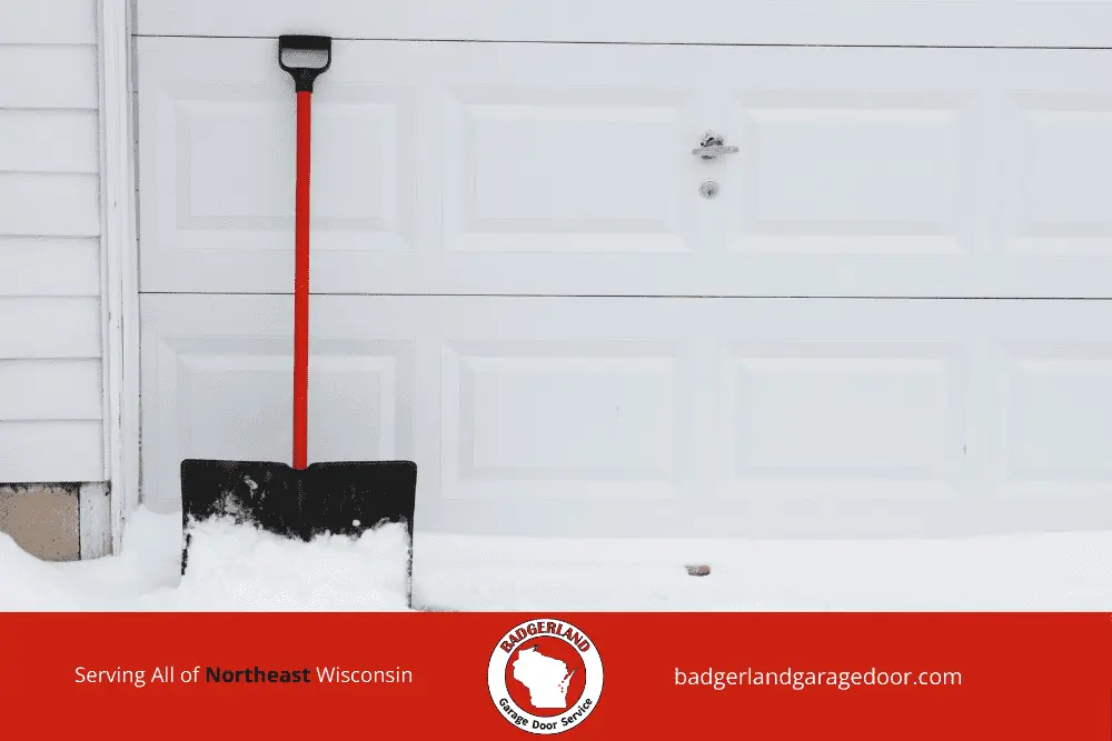 Snow piled against garage door that may cause freezing and sticking in winter. Bestland Garage Door Service.
