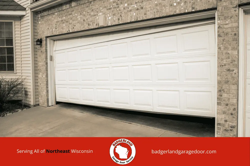 Why Garage Door Balance Matters More in Wisconsin Winters-2 White garage door halfway open, needing repair service in Wisconsin, highlighting garage door repair expertise.| Bestland Garage Door Service – Green Bay & Appleton Garage Door Repair