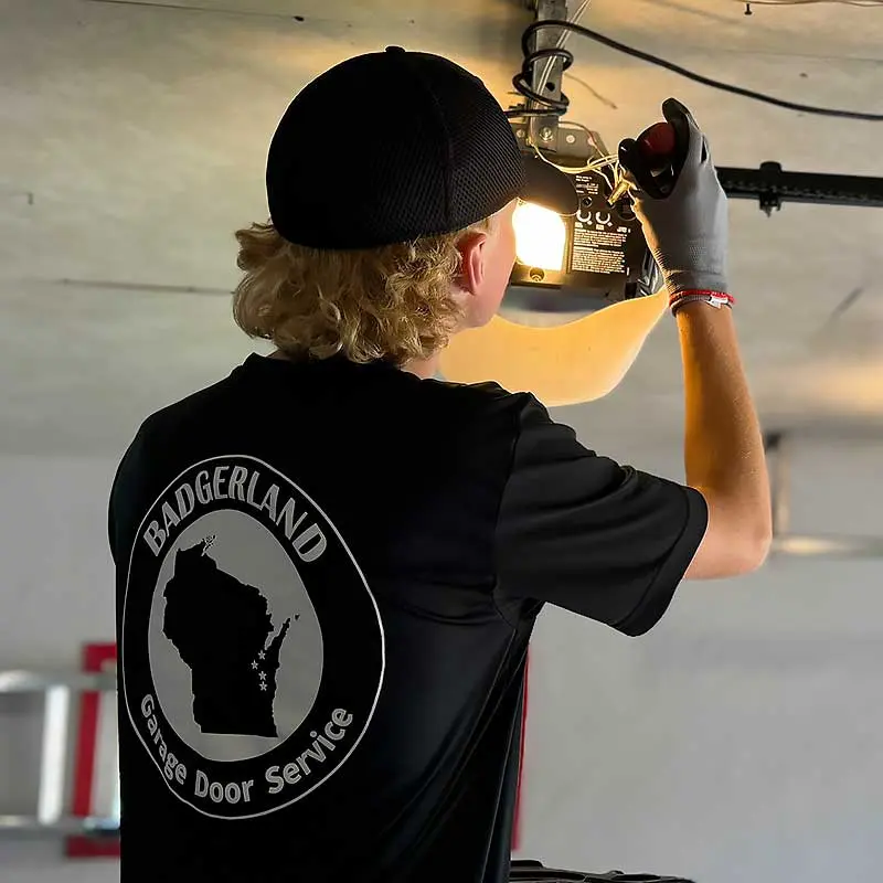 Technician repairs a garage door opener, wearing a Bestland shirt, serving Green Bay and Appleton homeowners.| Bestland Garage Door Service – Green Bay Garage Door Repair