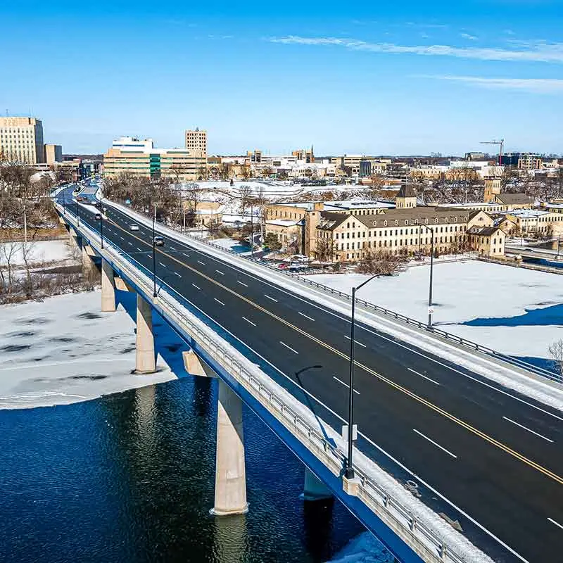 A snow-covered Appleton cityscape with a bridge over a frozen river under a clear blue sky.| Bestland Garage Door Service – Green Bay Garage Door Repair
