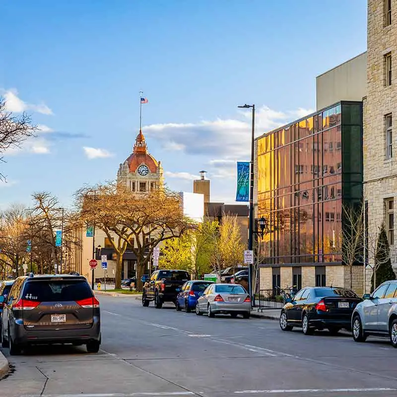 Street view in Appleton with cars parked alongside buildings under a blue sky.| Bestland Garage Door Service – Green Bay Garage Door Repair