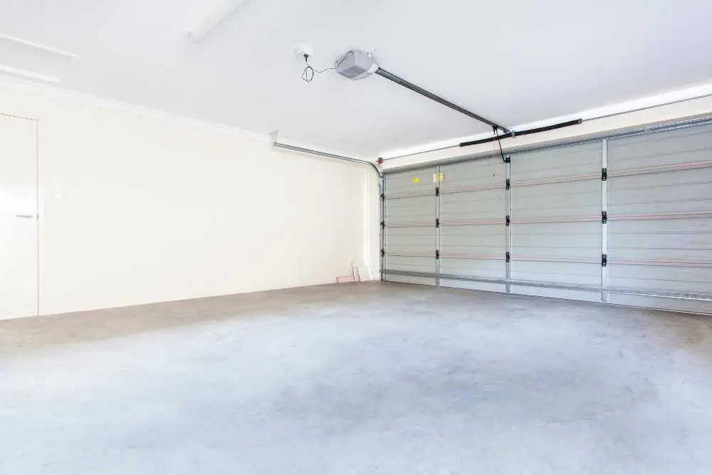 A clean, empty garage with a closed, silver sectional door and a smooth concrete floor, highlighting the need for garage door repair services in Green Bay and Appleton.| Bestland Garage Door Service – Green Bay Garage Door Repair